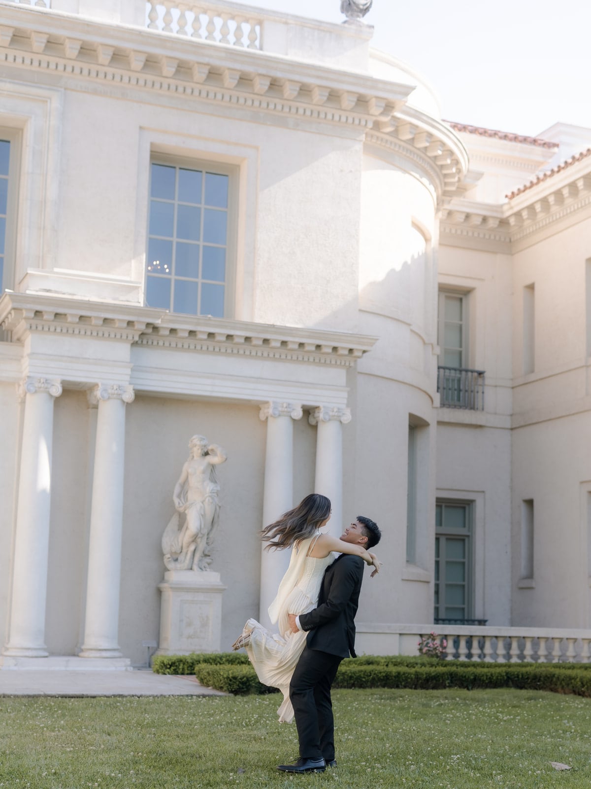 Edwin lifting Grace outside an estate during their engagement shoot